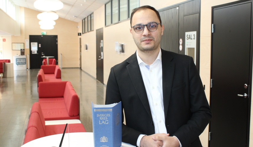 Fuad Heydarov står lutad mot ett bord och har lagboken framför sig