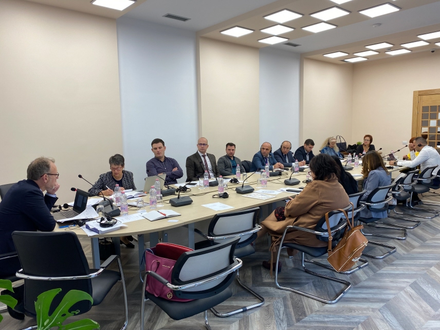 Flera personer i möte vid ett stort bord