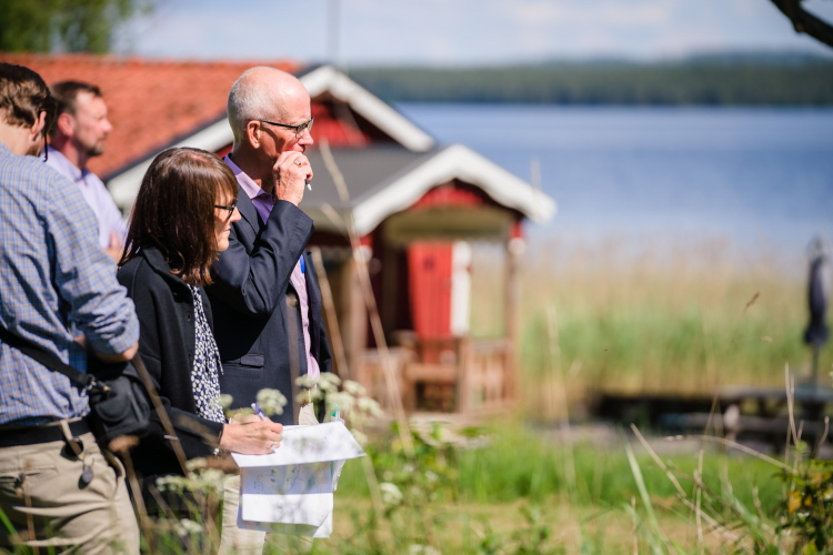 Fyra personer vid en sjö som antecknar. Foto.