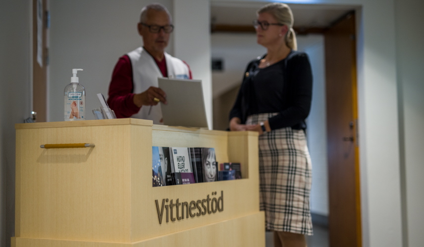 Vittnesstödjare ger information till besökare vid en domstol.