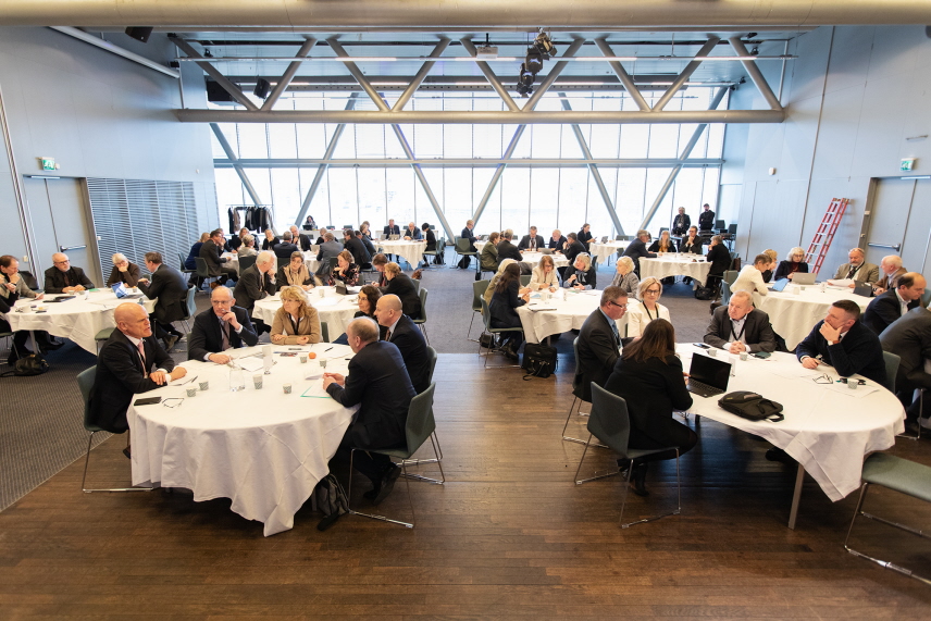 Många domstolschefer som sitter vid runda bord och samtalar. 