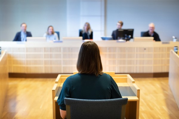 Vittne i vittnesbås inför sittande rätt