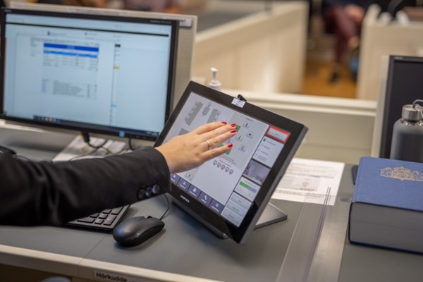 En hand som pekar på en dators pekskärm. Foto.