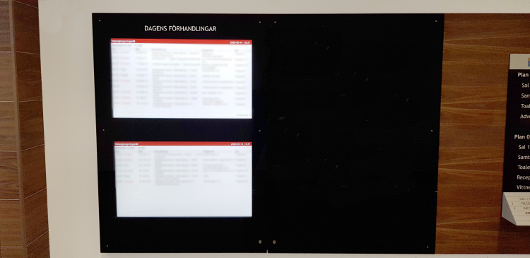 Digital anslagstavla som visar dagens förhandlingar. Foto.