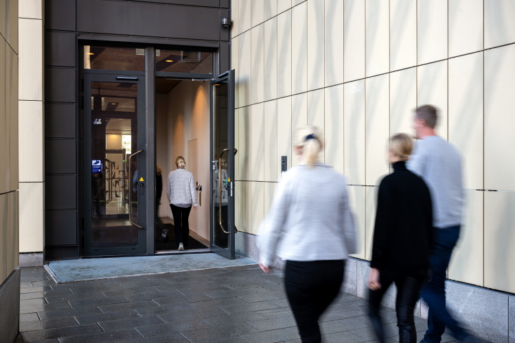 Tre personer går in genom domstolens entré.