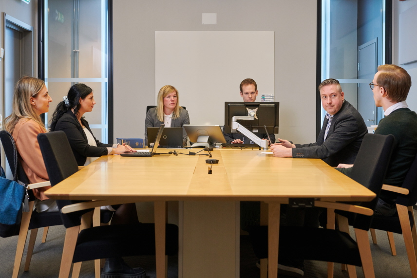 Sammanträdesrum med parterna och deras ombud, samt domare och protokollförare. 